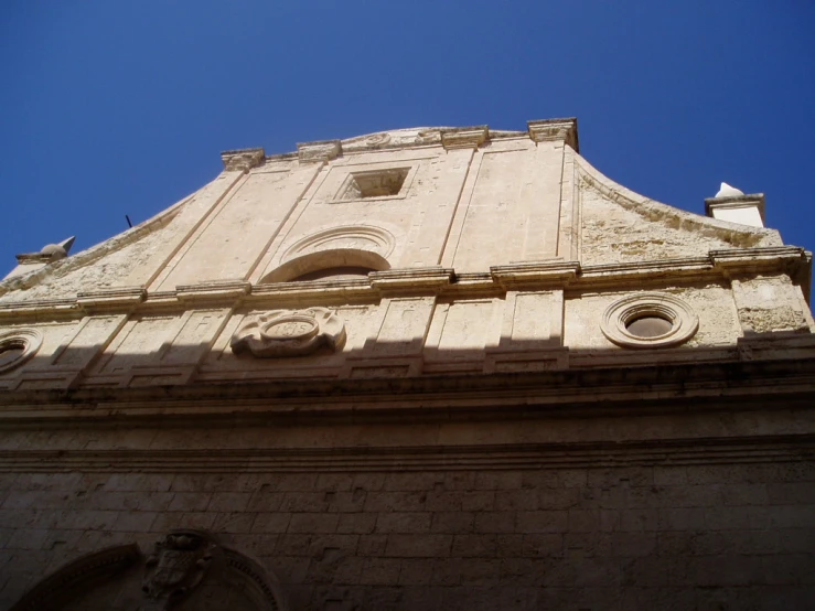 the back side of a building with a clock on the top of it