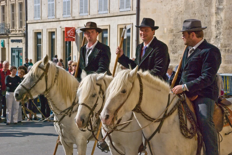 the men ride down the street on horses