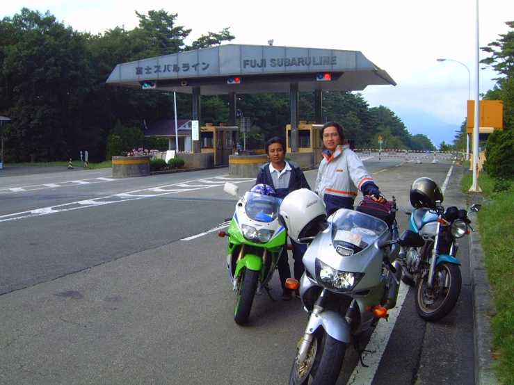 two people are posing for the camera with motorcycles