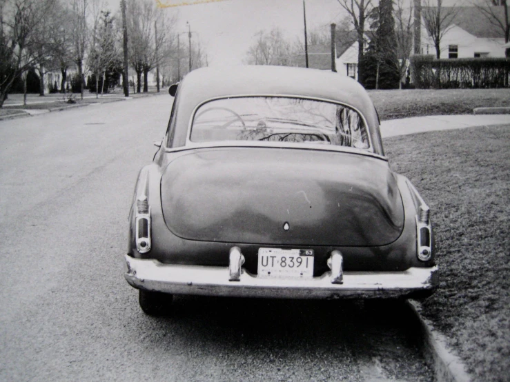 a small vintage car parked on a street