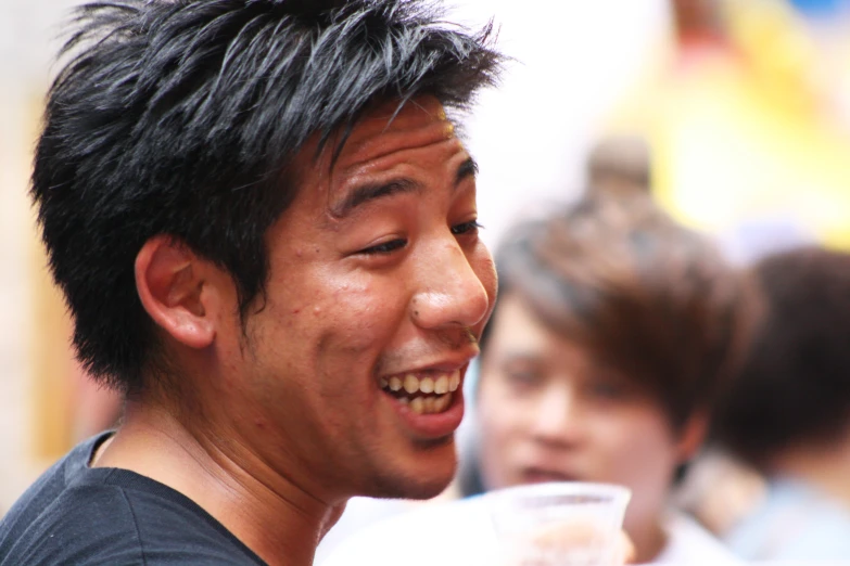 asian man laughing with others on background
