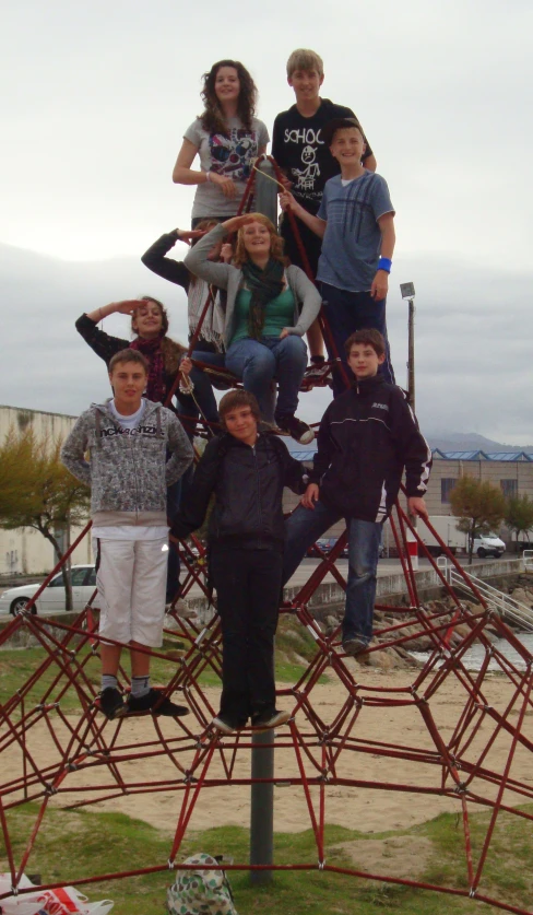 a group of young people standing around a metal structure