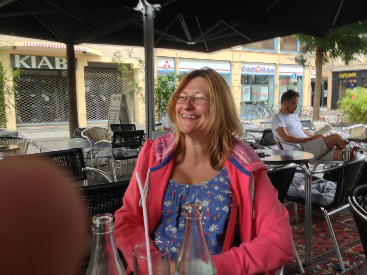 a woman smiles outside at an outdoor restaurant