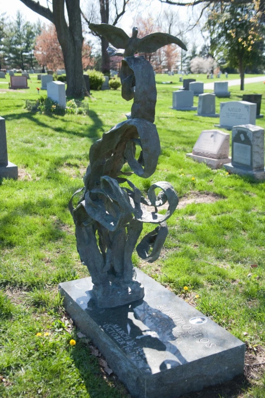 a sculpture in the grass with trees in the background