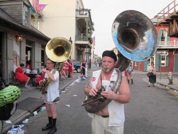 a man is holding up two trumpet players as people look on