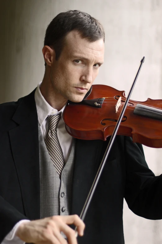 a man in suit and tie playing the violin