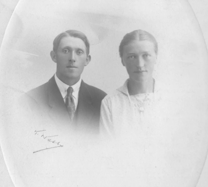 an old pograph of two people with a hat on