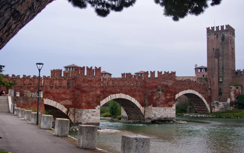 bridge over water with ancient brick building and towers