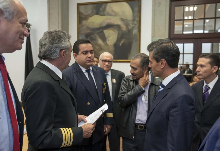 men in suits talking while standing around each other