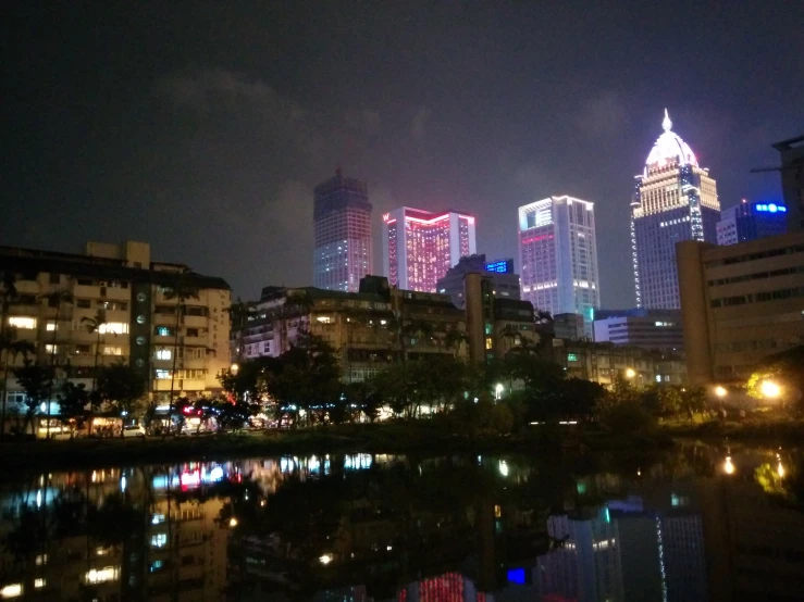 a body of water with buildings lit up in the background