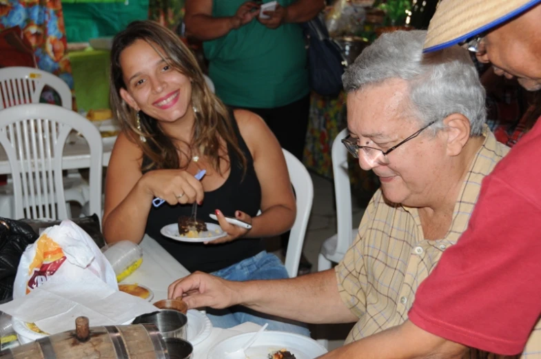 two women and a man eating a meal at an outdoor table