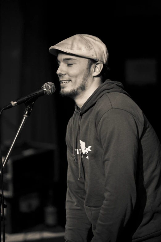 a man in a hat is singing into a microphone