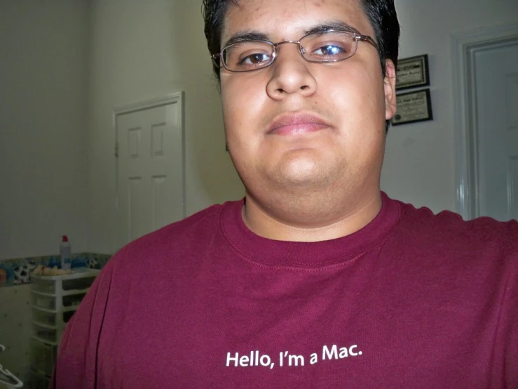 a man wearing glasses and a hello i'm a mac shirt