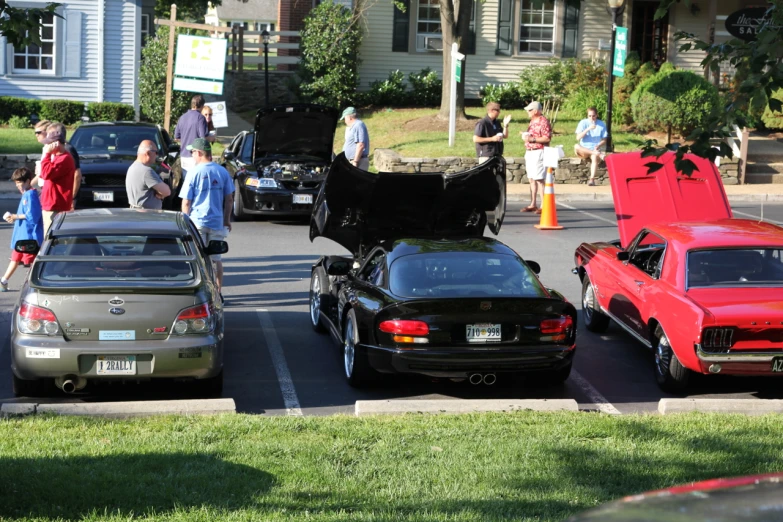 two cars with the hood open at the same time