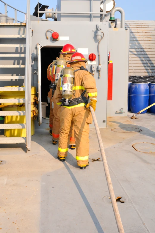 two fire fighters standing next to a ladder