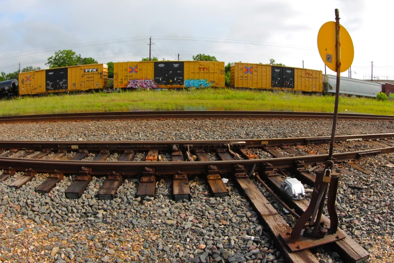 an aerial s of train tracks with yellow and black trailers behind them