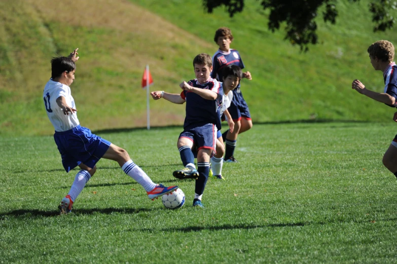 boys playing soccer with each other on the field