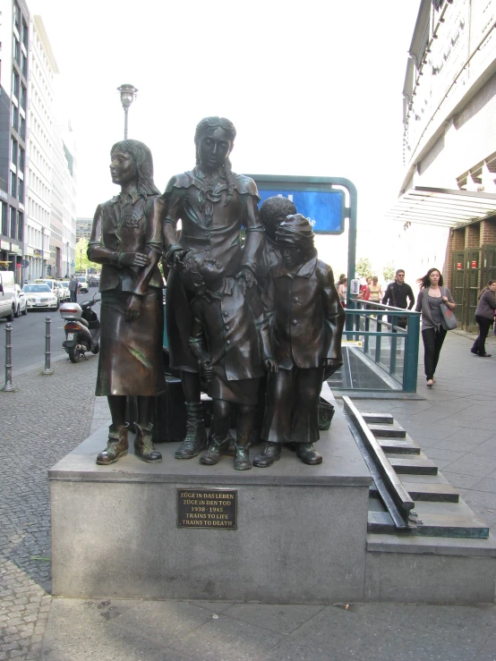 a statue of several children on a sidewalk