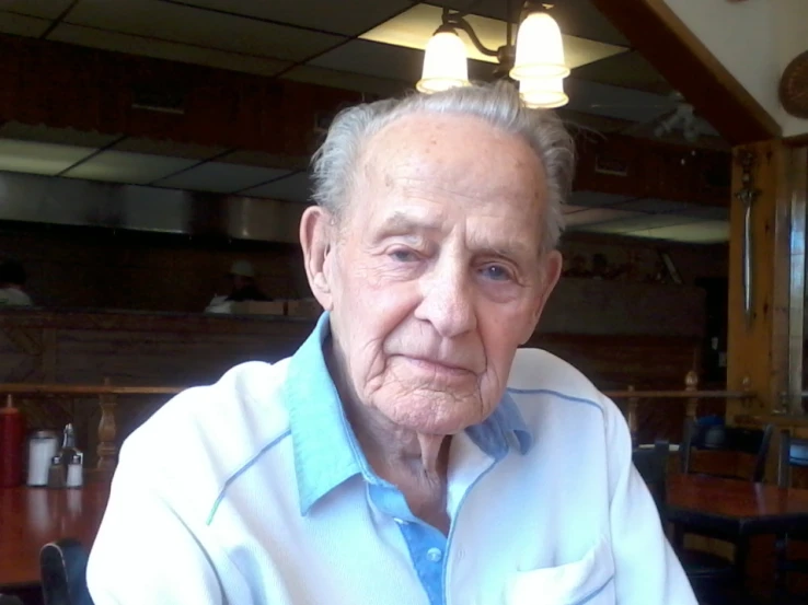 an old man with grey hair sitting down