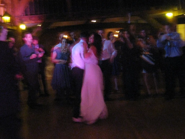 a group of people dancing around in a dark room