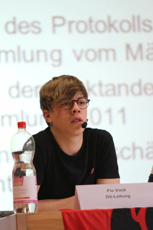 a boy with glasses and a bottle of water