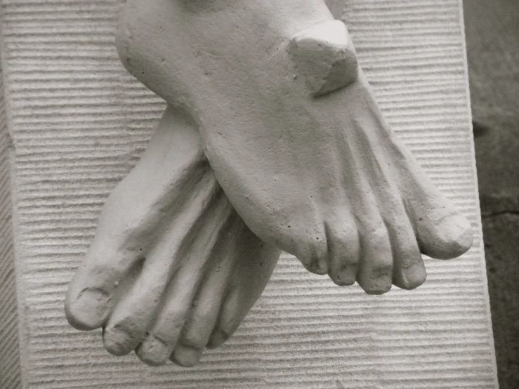 the foot of a sculpture of a person's hands