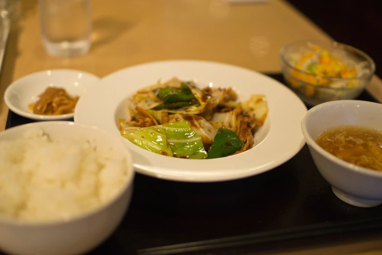 a table with three plates of food and one bowl of rice