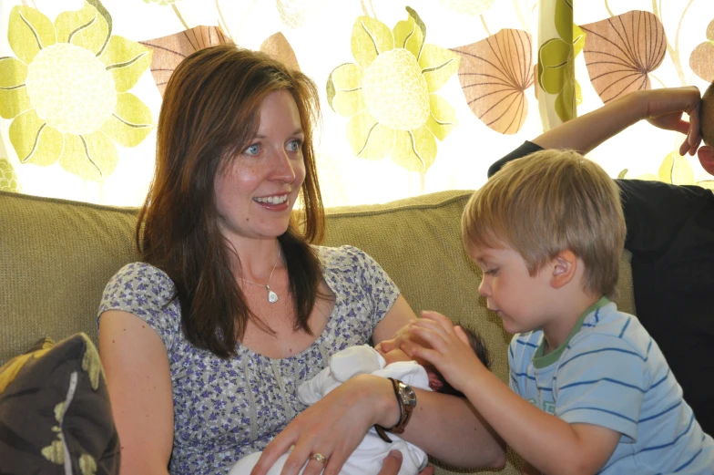 a woman holding a toddler while he has an infant