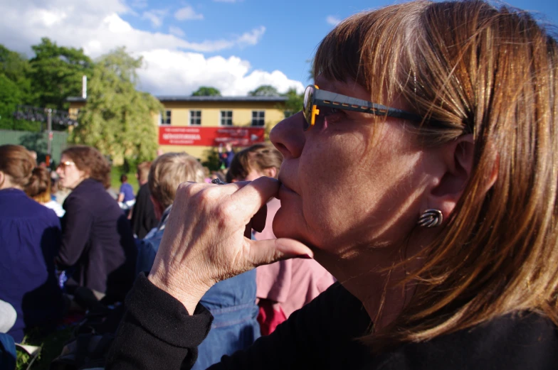 a woman with sunglasses on takes a bite out of a pastry