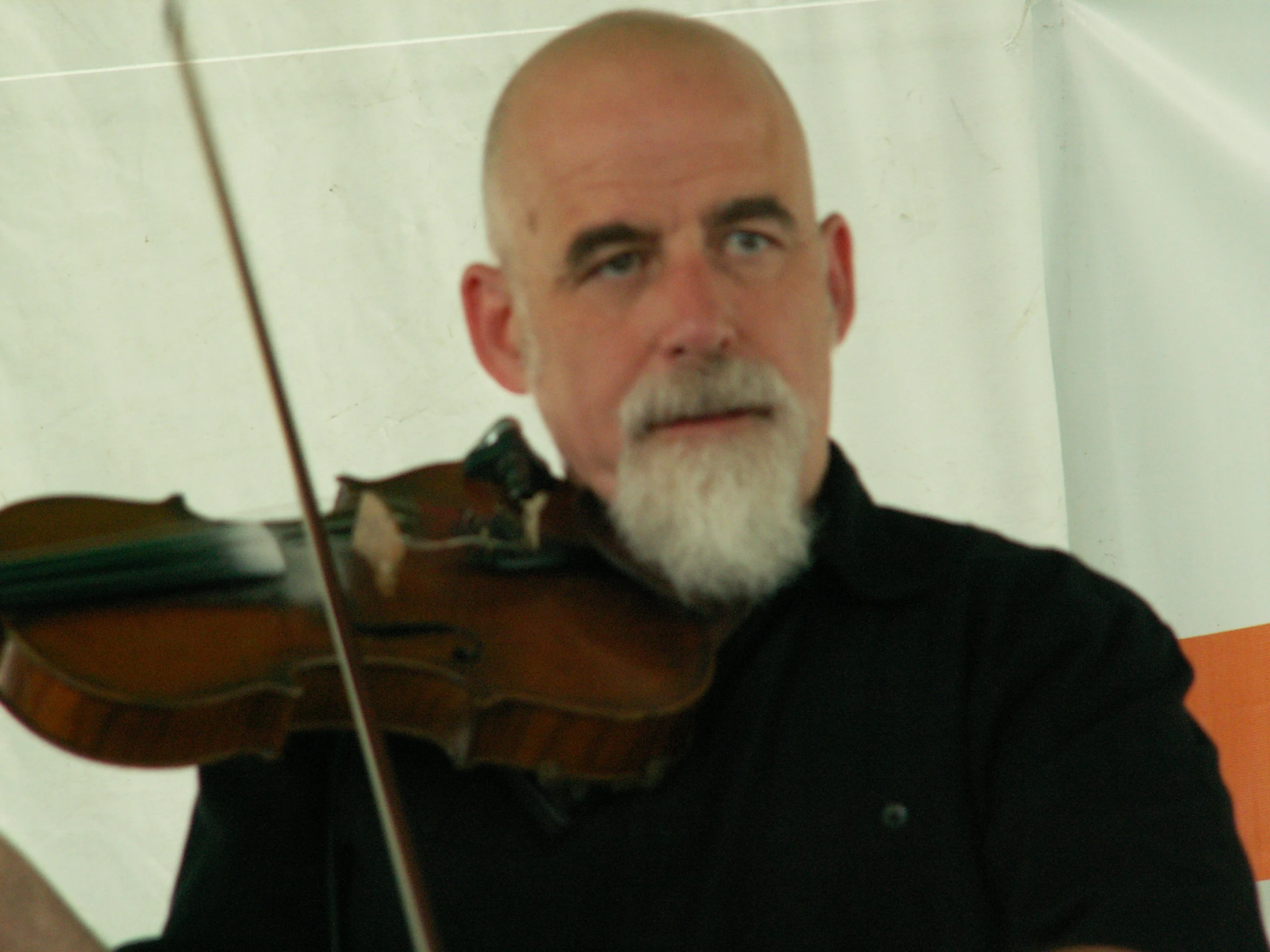 man with beard playing violin and looking forward