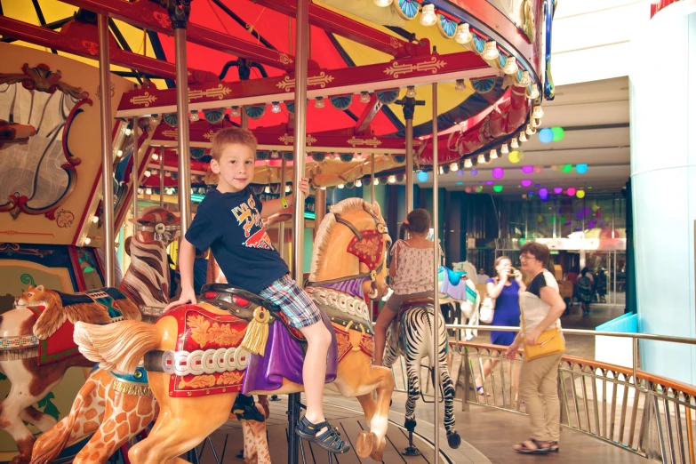 a boy standing on top of a carousel ride