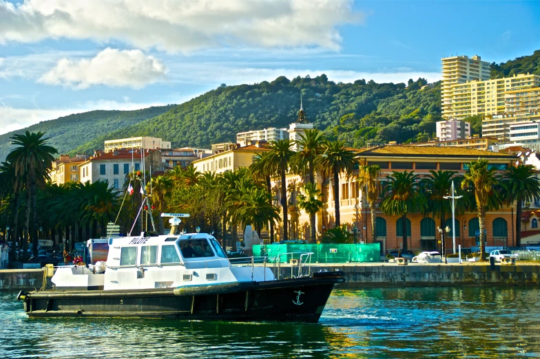 a white boat in the water near buildings