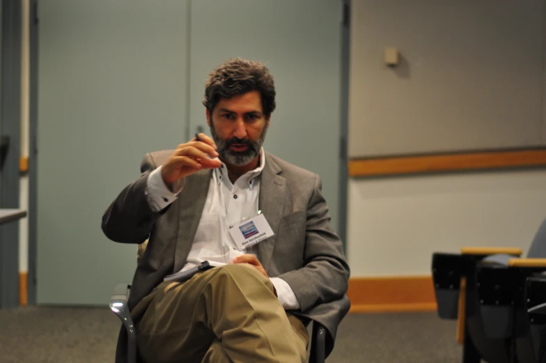 a man is in a chair holding a business card