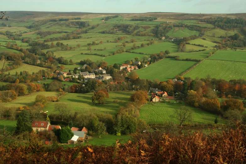 a small town surrounded by green fields and trees