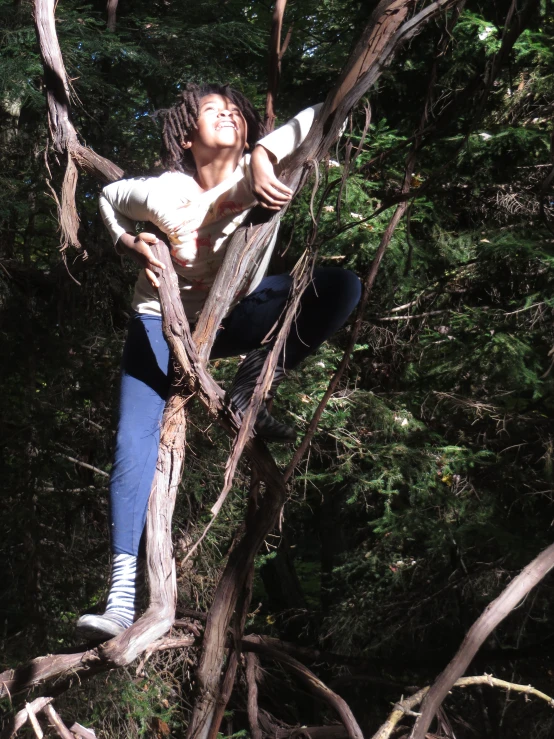 a woman standing on a tree trunk posing for a picture