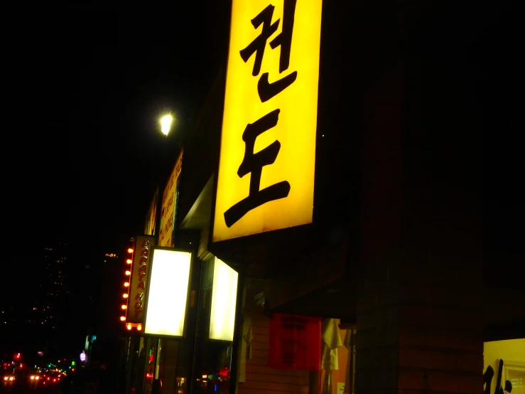a chinese business sign in the night with light and building