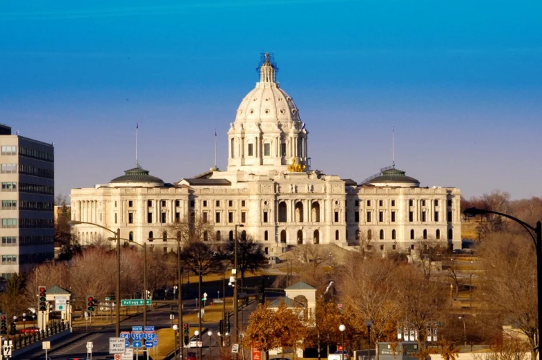 a large white building with three towers near some buildings