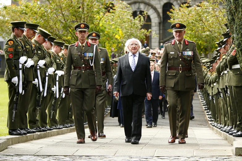 several people in uniforms walking down a sidewalk