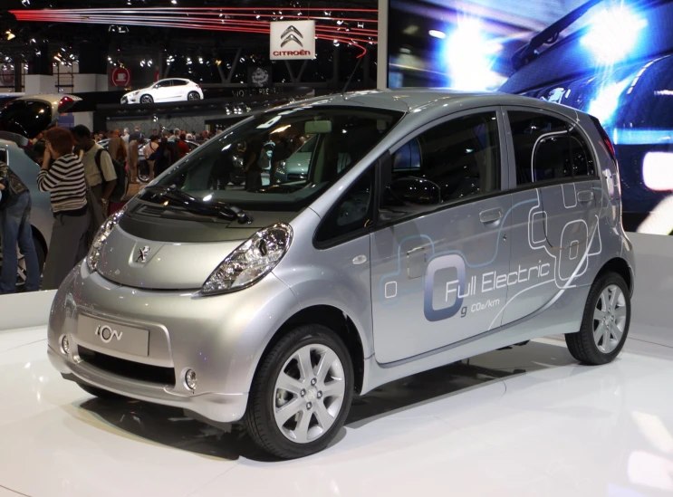 an electric car is on display with people