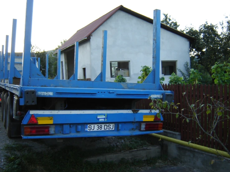 a blue truck is parked on a curb in front of a house