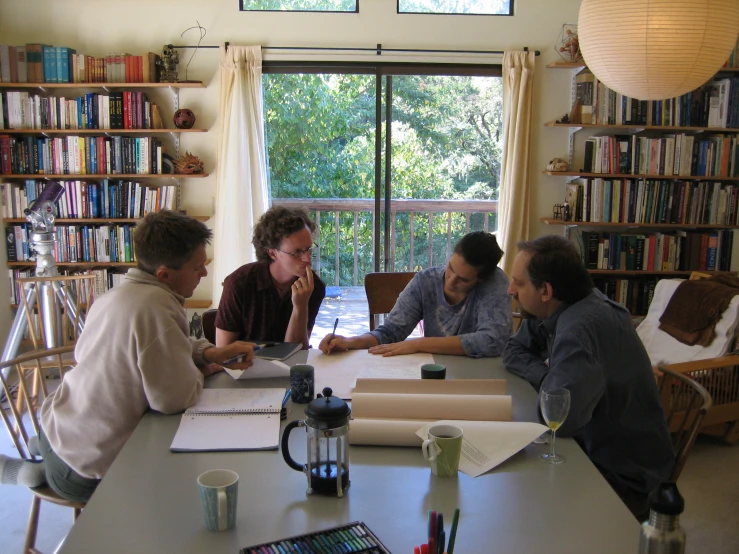 four men are sitting at a table together