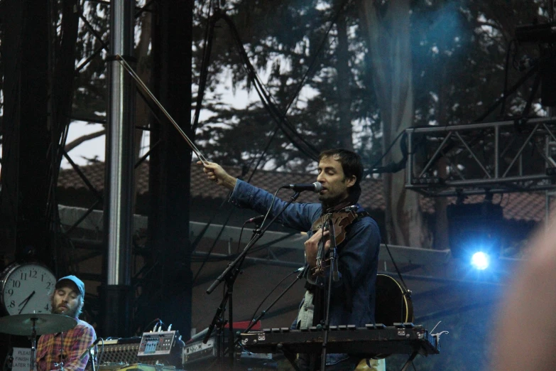 a man is performing on stage with other people