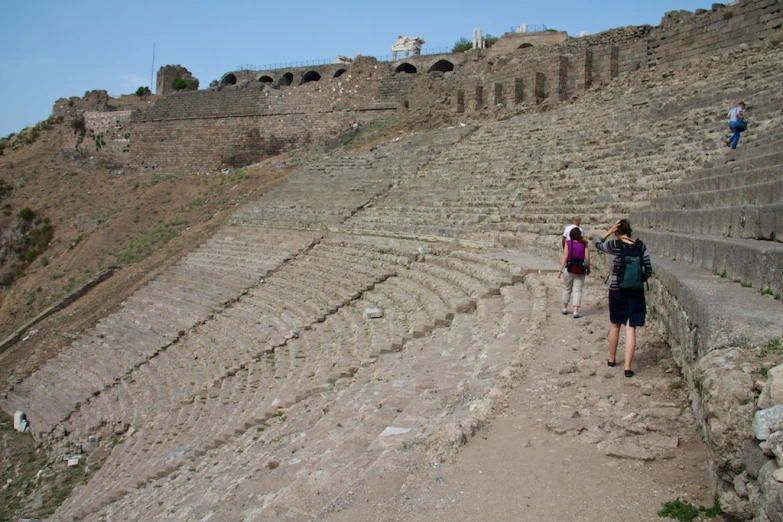 people walking up stairs near an ancient ampurines