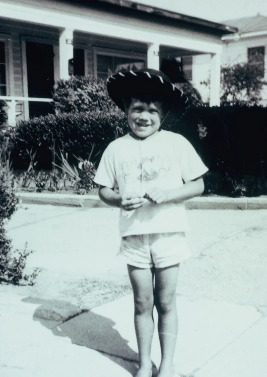 a child smiles while holding soing in one hand and an object in the other