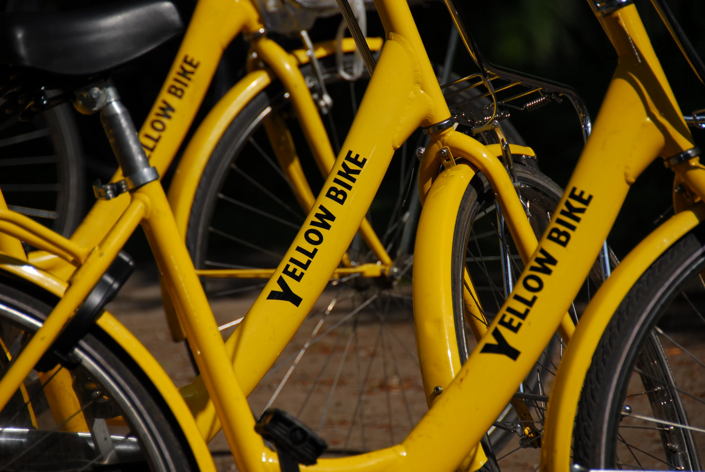 two yellow bikes with a white bike seat on it