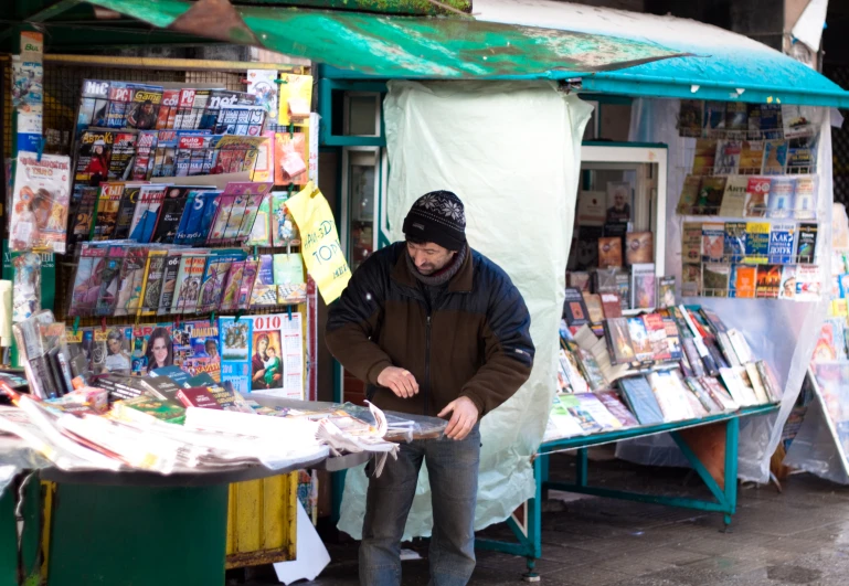 a man in a black hat working at a stand