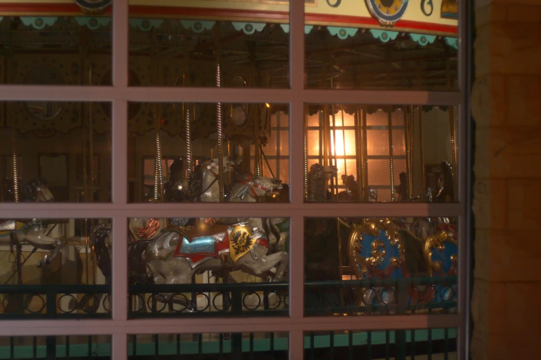 a window with a carousel at night through the glass