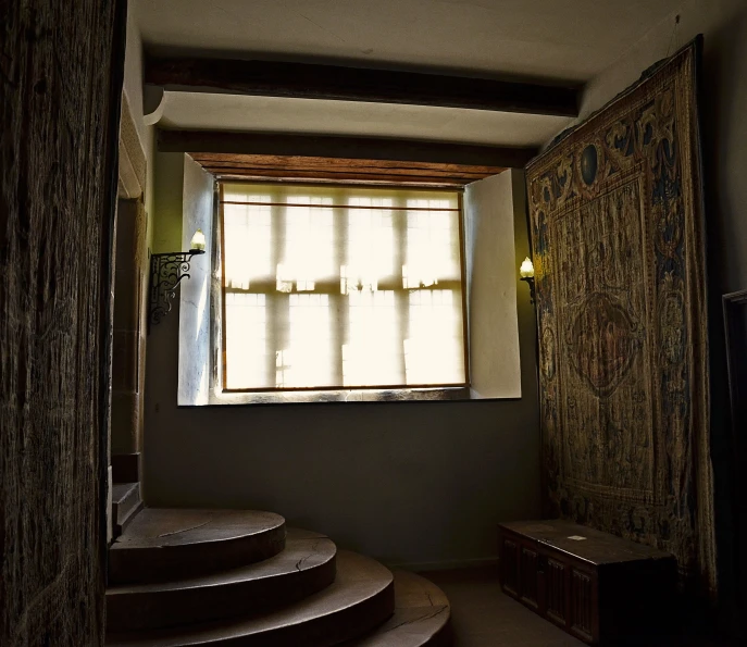 a room with a window on the far wall and set of stairs leading up to the outside