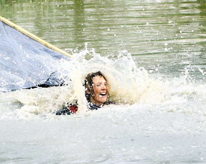 a person in a body of water with a sail