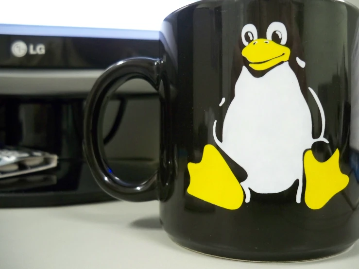 a black mug with a yellow beak sits on a table